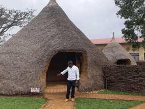 A person in front of a hut
